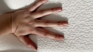 Reviewer's hand resting on cover of Origin Hybrid mattress