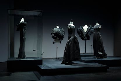 ‘Balenciaga in Black’ at Kunstmuseum Den Haag. Different styled black dresses and tops on mannequins on a raised platform.