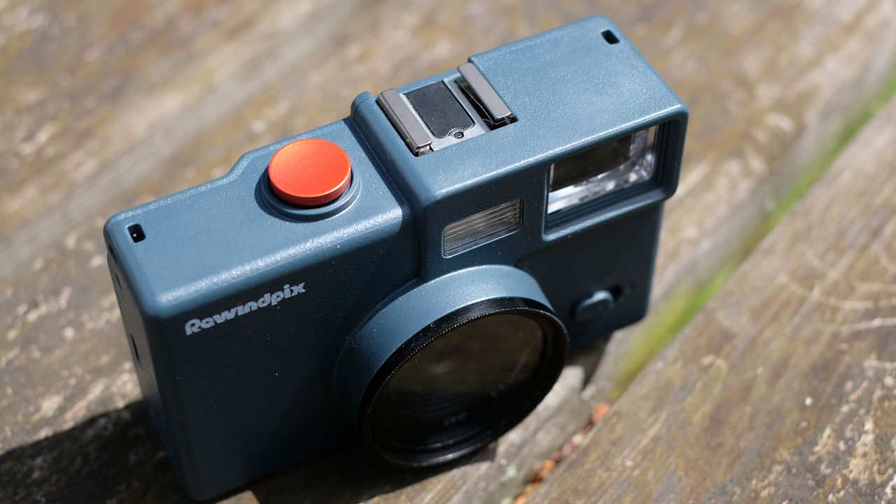 Photograph of RewindPix digital compact camera showing top plate with large red shutter button