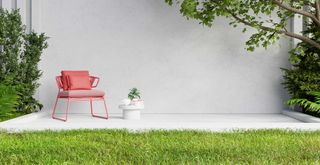 contemporary garden with a clean stone patio with a coral colored garden chair and small side table
