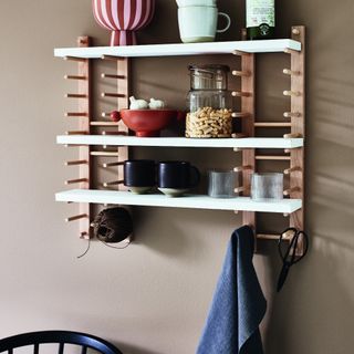 A light brown-painted kitchen wall with open shelving