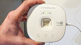 My Q Chamberlain Smart Garage Controller in a persons hands