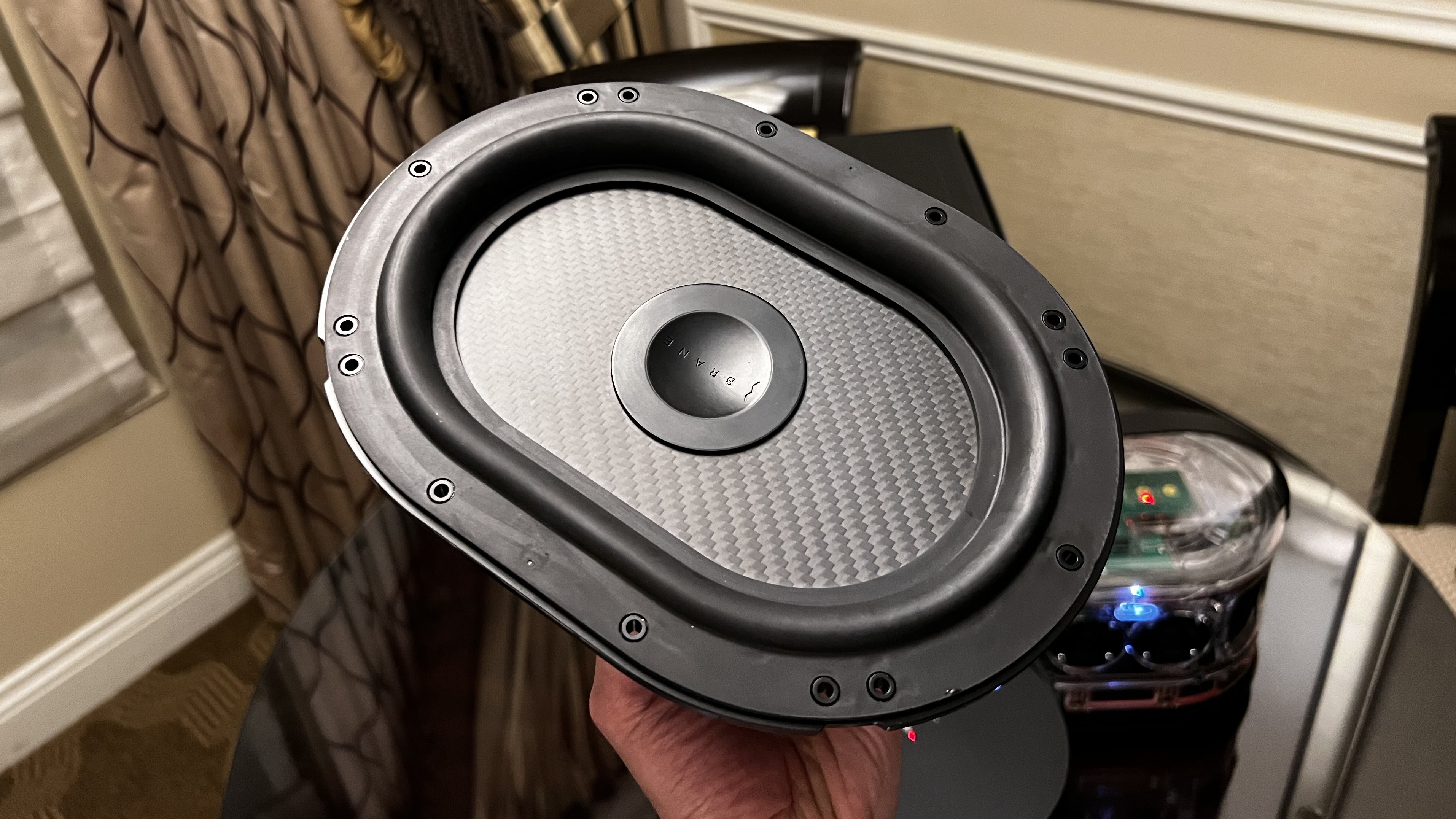 The Brane X speaker's subwoofer unit in a man's hand
