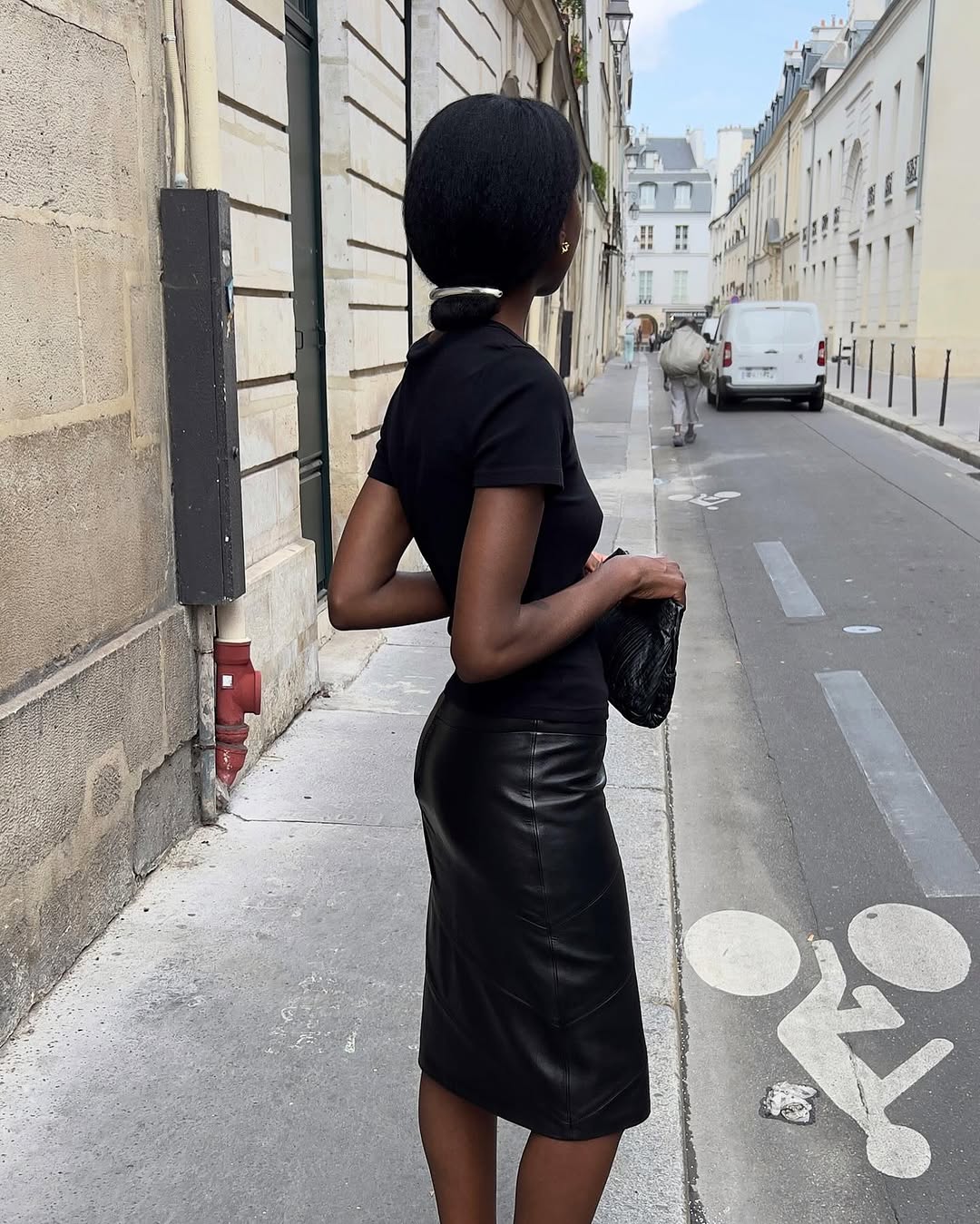 A woman wearing a T-shirt, knee-length black skirt and silver hair clip, part of Spring Basics Outfits 2026.