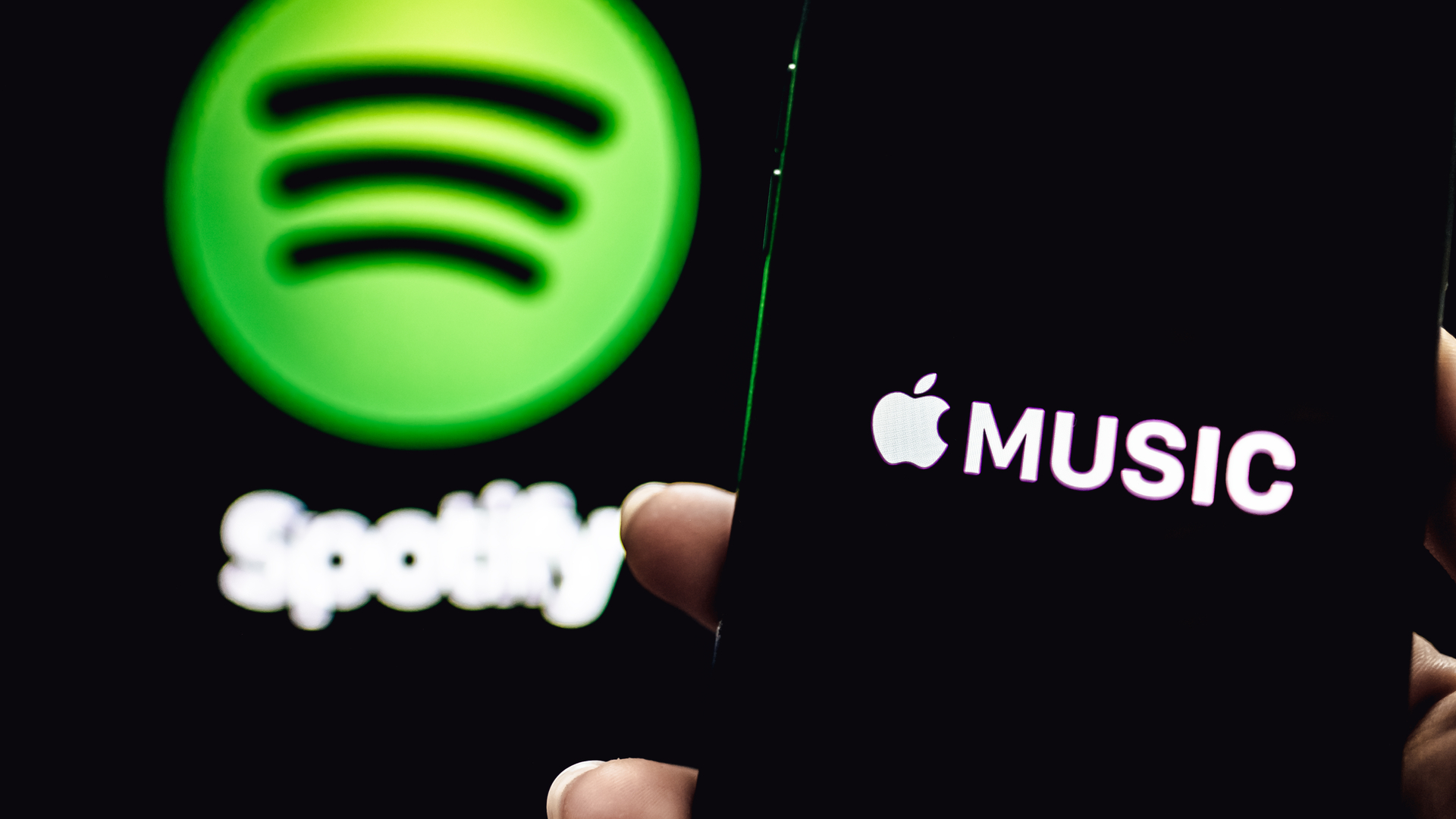 a spotify logo and an apple music logo on smartphones