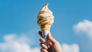 Ice cream in a cone held up to the sky