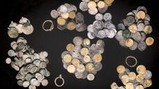 piles of gold and silver coins and rings spread out on a black background