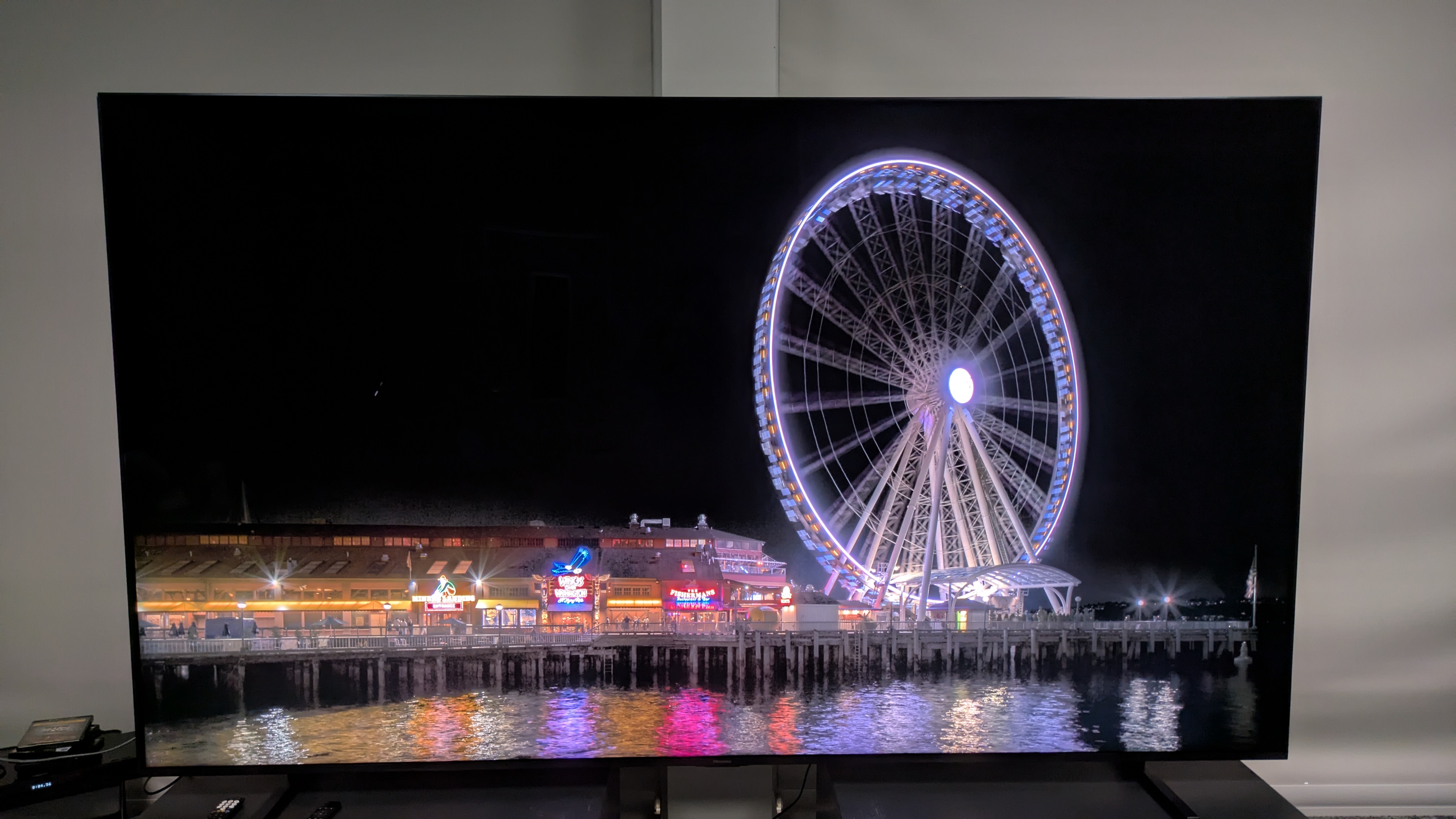 Hisense 116UX RGB mini-LED TV with ferris wheel at night on screen