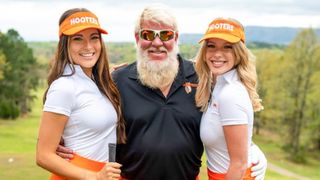 John Daly poses with two Hooters girls
