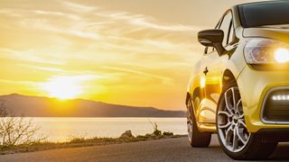 a car with a sunset behind it