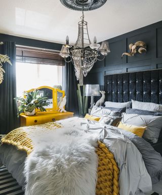 Bedroom with charcoal walls and coordinated painted ceiling rose, and upholstered button-back headboard