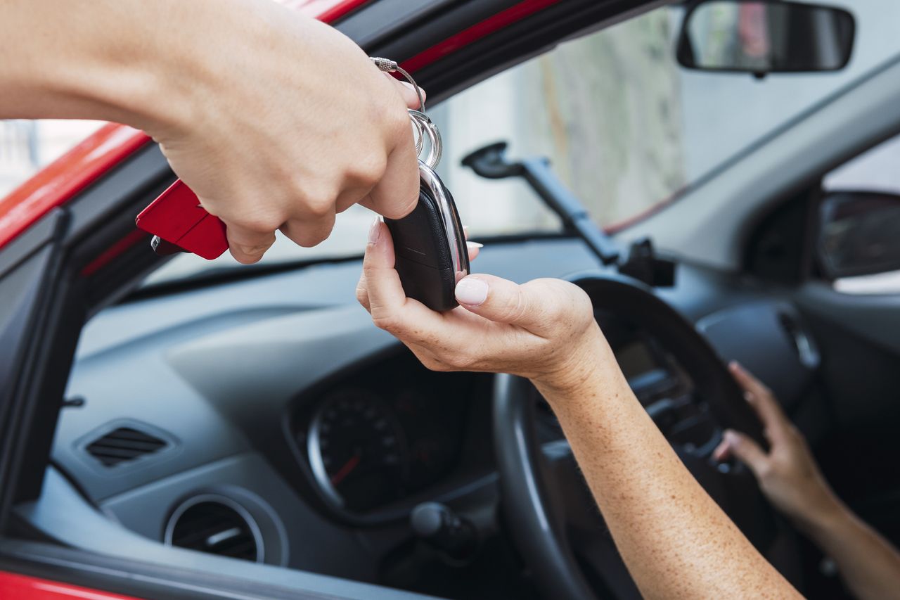 Salesman handling keys to customer 