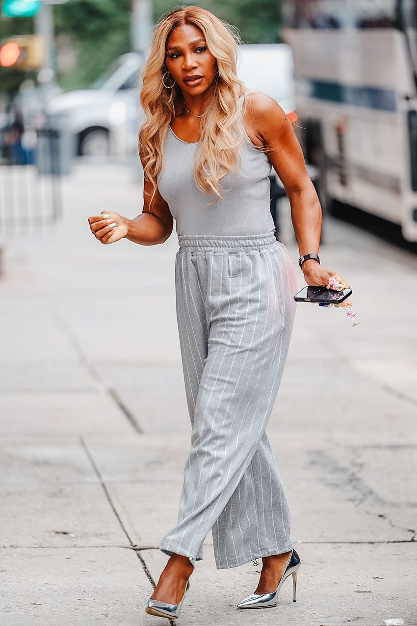 Serena Williams wearing a gray tank top, gray striped pants, and silver pointed-toe heels in NYC