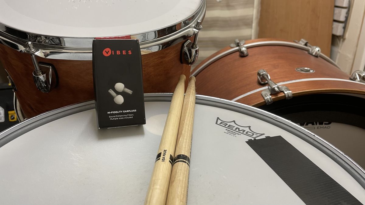 Vibes Hi Fidelity Earplugs on top of a snare drum next to a pair of drumsticks