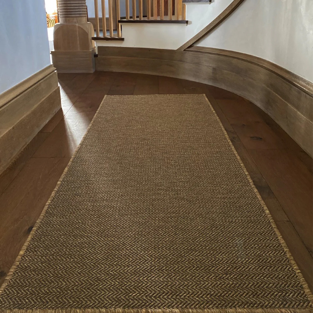 Woven runner in a hall with a hard wood floor and blue walls
