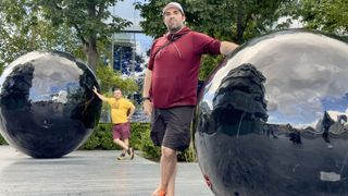 man standing next to large ball