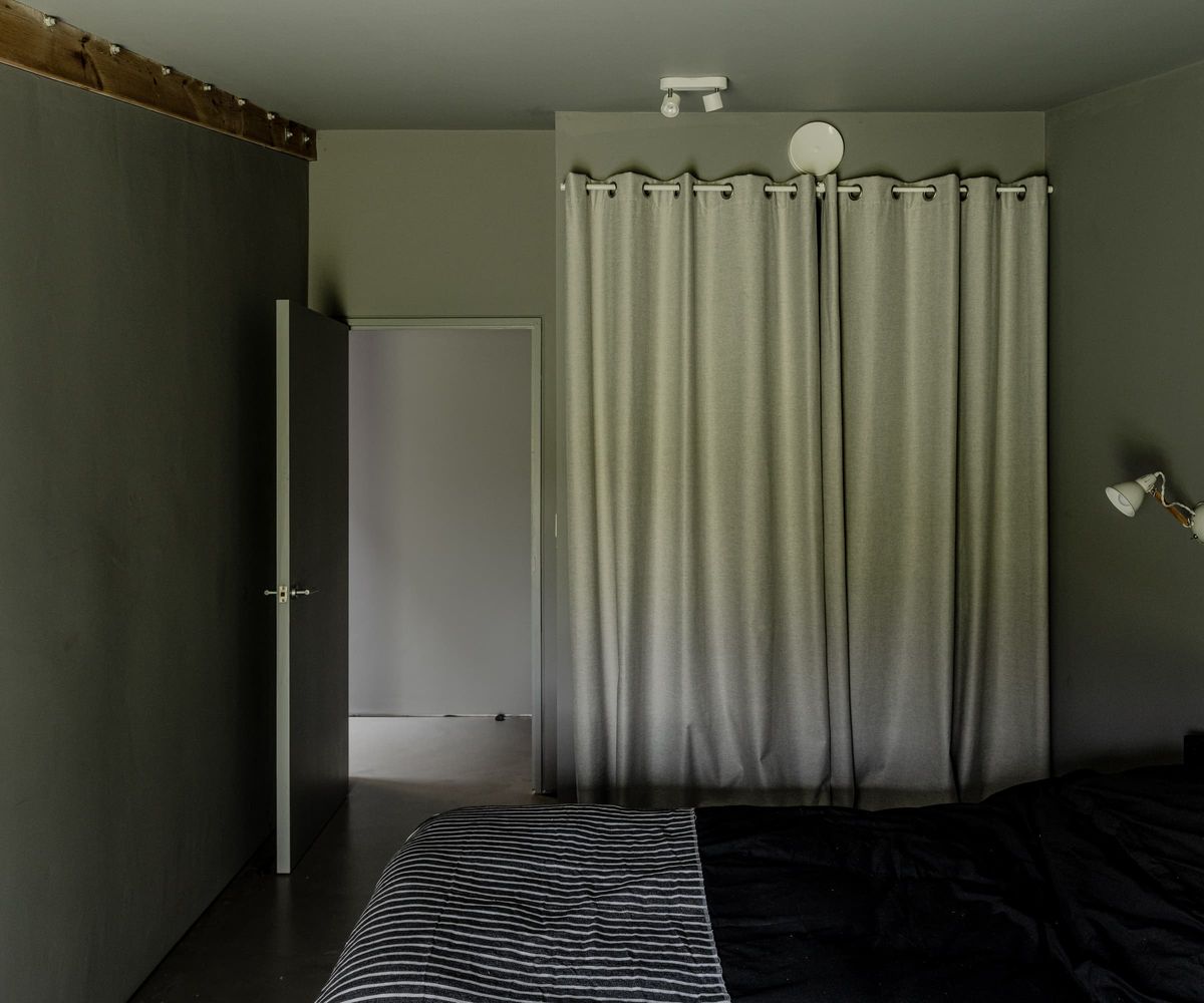 A black bedroom with a white curtain