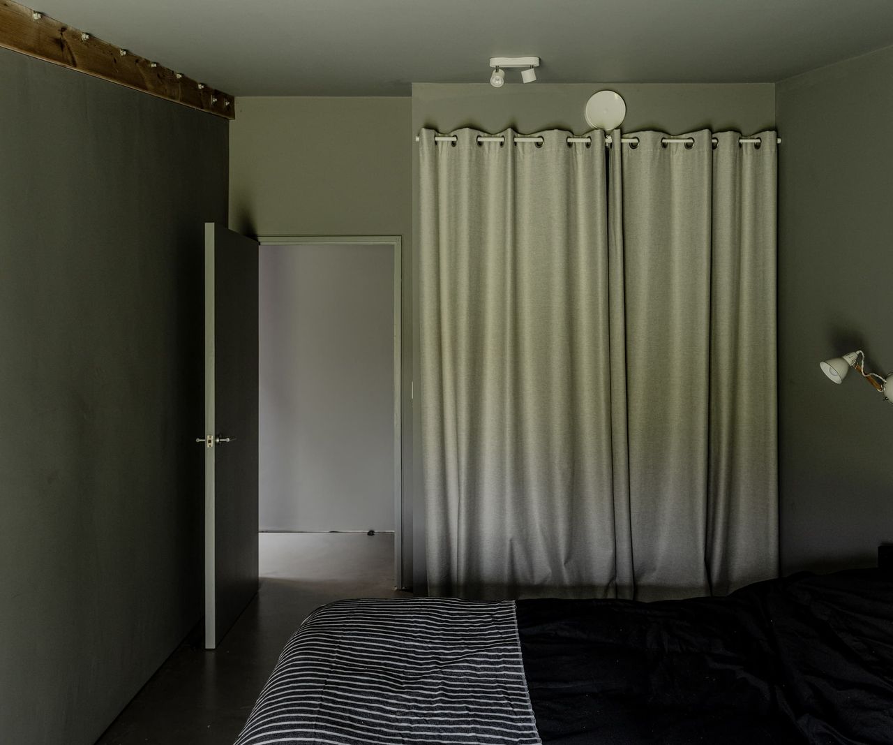 A black bedroom with a white curtain