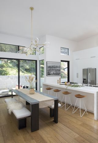 white kitchen and dining room with kitchen island hob by Sarah Rosenhaus