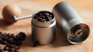 A handheld coffee grinder with coffee beans inside