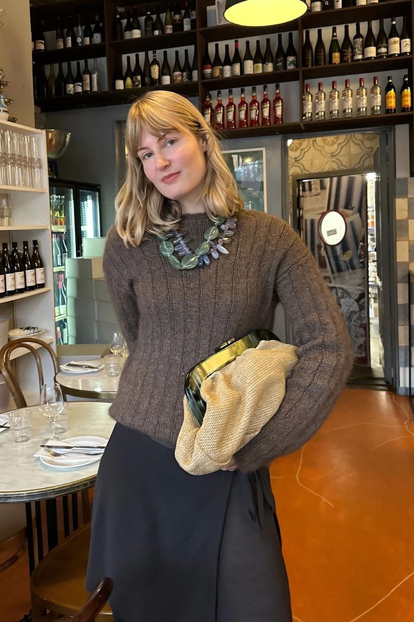 a woman holding a large pouch clutch bag