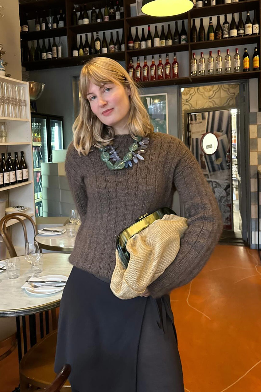a woman holding a large pouch clutch bag