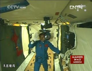 China's Shenzhou 9 mission commander Jing Haipeng waves to a camera after boarding the Tiangong 1 space module following a successful June 18, 2012 docking, China's first manned orbital rendezvous, in this view from state-run TV news.