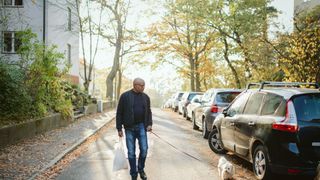 Man walking dog on sidewalk
