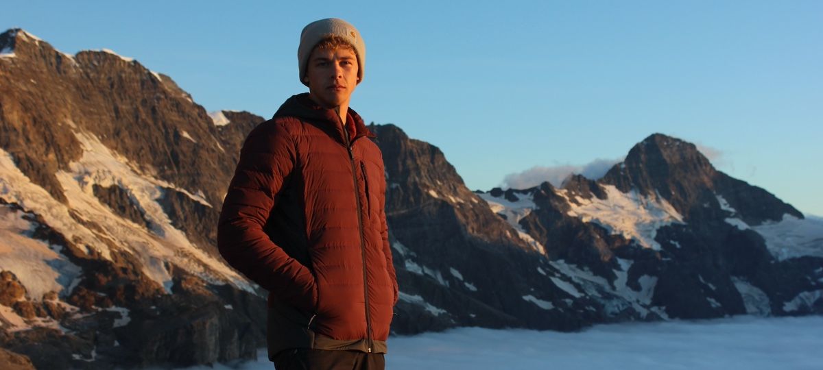 Man wearing an Artilect M-Divide Fusion Stretch Hoodie in the Alps