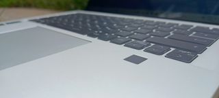 A silver MSI Prestige 14 Evo B13M laptop sitting on a patio rock