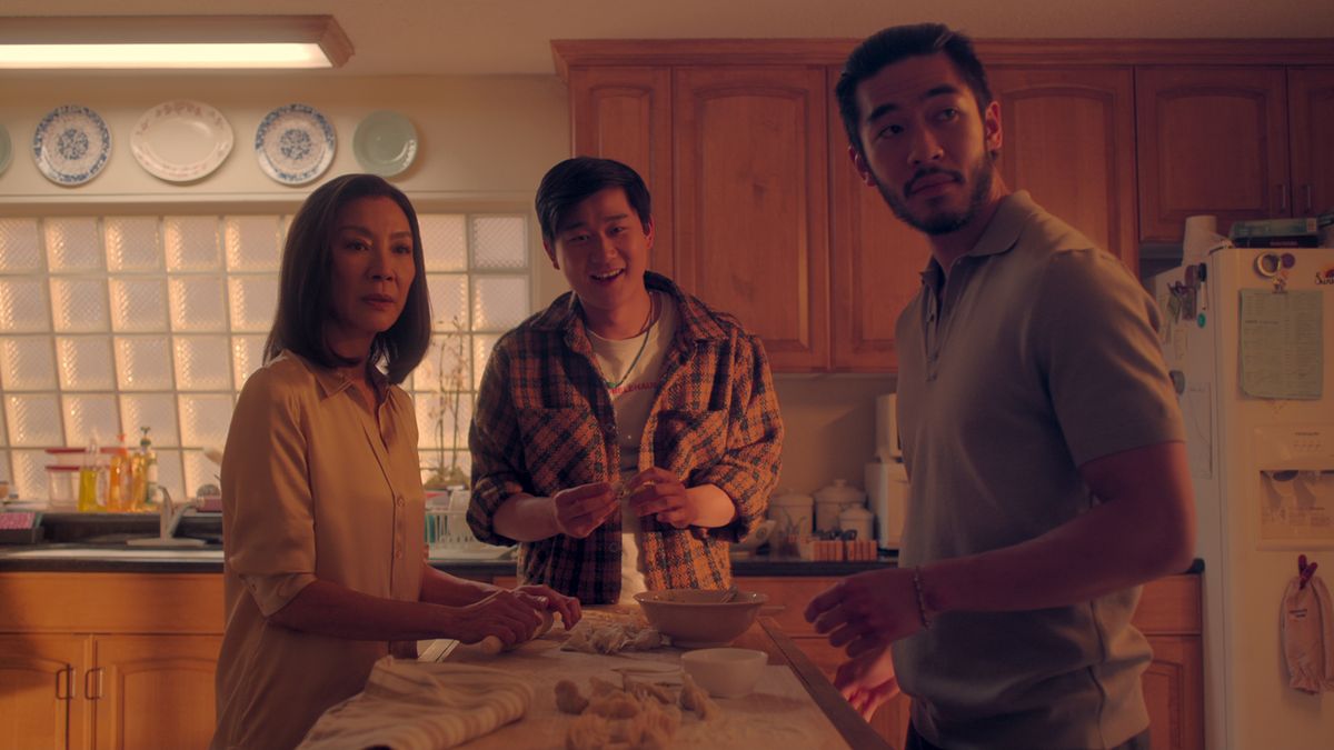 Two men and a woman gather around a kitchen table in The Brothers Sun