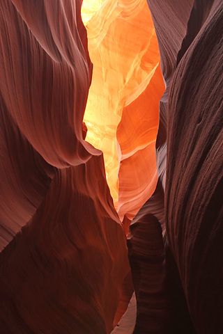 Some sections of the Lower Antelope Canyon are wide, flat and sunny, while others are much narrower and darker like a cave, with barely any light reaching the sandy floor.