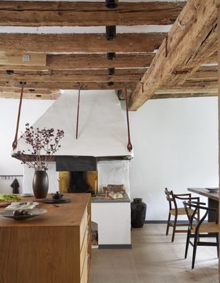 Rustic wooden kitchen island ideas in a country cottage-style space with beamed ceiling.