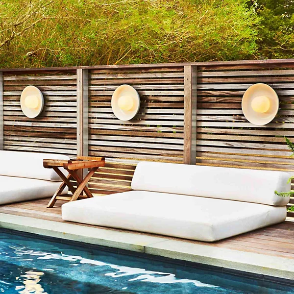 Outdoor wall sconces illuminating pool area