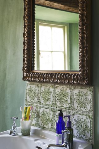 period mirror and tile details in blue bathroom