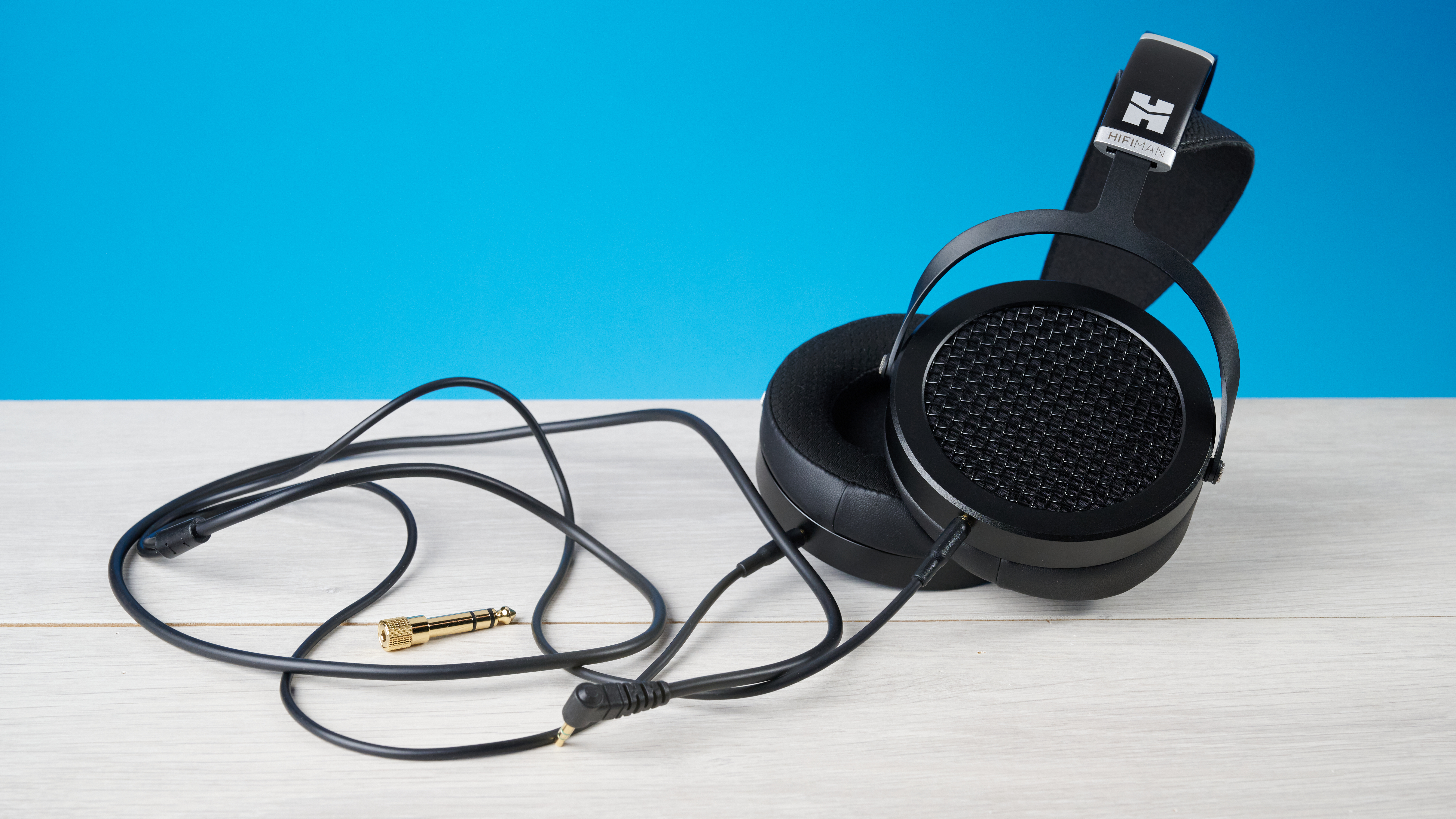 the HIFIMAN Sundara open-back wired audiophile headphones photographed against the blue toms' guide background