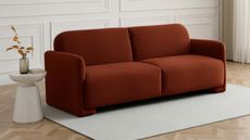 burnt orange velvet sofa on a grey rug 