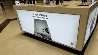 An apparent in-store poster of the Galaxy S24 Ultra, advertising the design and its AI features in Brazilian Portuguese