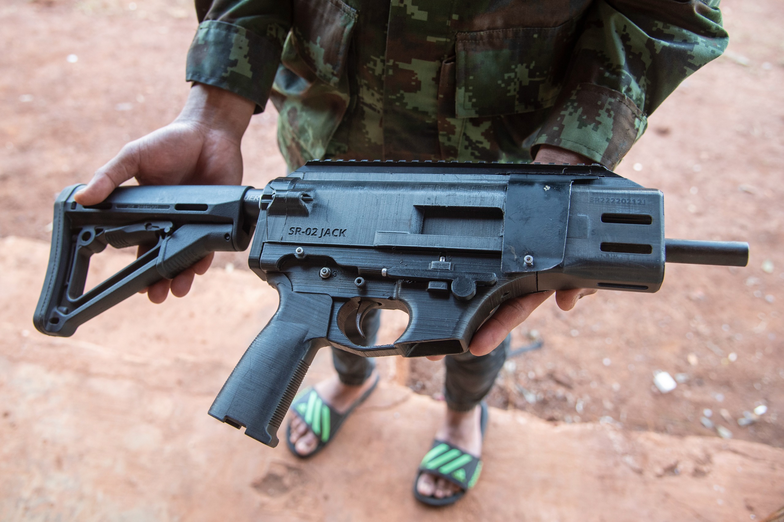 Soldier in flip flops holding 3D printed gun