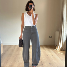 Marianne wearing a white vest and grey jeans