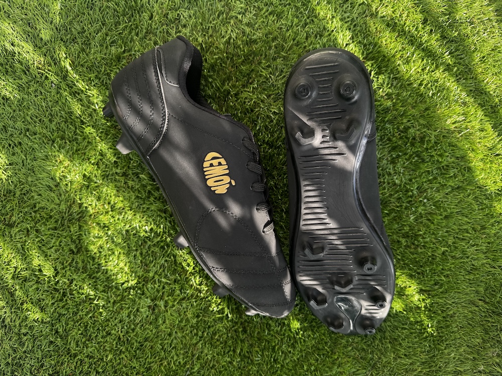 Black Lemon football boots on green grass