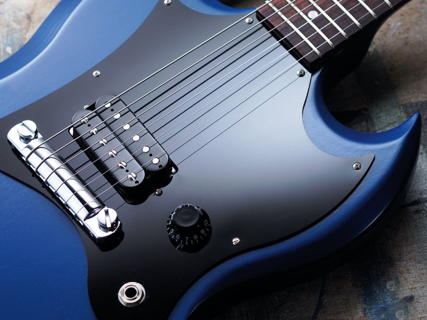The guitar's grain is visible through its paintwork.