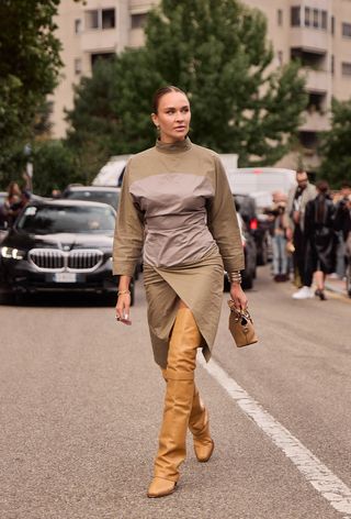 Milan Fashion Week spring 2025 street style photo of a woman wearing the over the knee boot trend