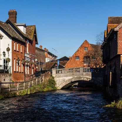 city with houses and flowing river under the bridge
