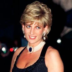 Princess Diana wearing a blue low cut dress and pearl choker