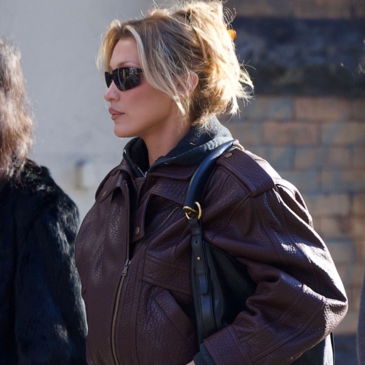 Bella Hadid was spotted at breakfast at Sadelle's in Soho on Monday afternoon with friends. The model wore a maroon leather biker jacket from Drejani, which she styled over a gray hoodie, with dark denim straight-leg jeans and Salomon sneakers. She finished her look with a Saint Laurent Mombasa bag.