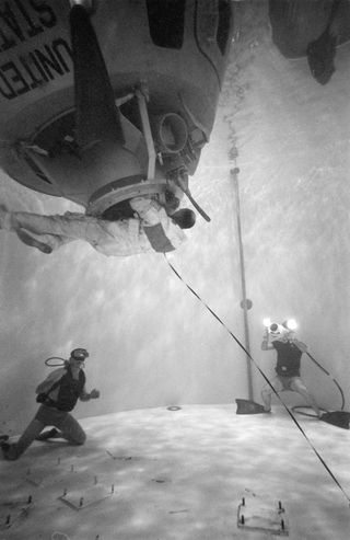 In a water tank inside the Manned Spacecraft Center in Building 260, astronaut Ken Mattingly, the original command module pilot of Apollo 13, completes a water egress training exercise.