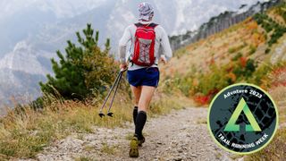 Man running on trail with trekking poles