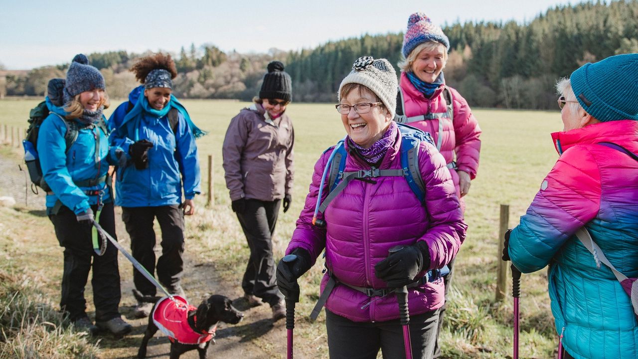 walking clubs: group of women walking outside with poles and hats