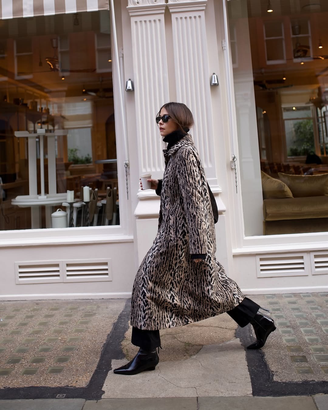Alice Satterthwaite in an animal-print coat, black turtleneck, and black wedge boots.